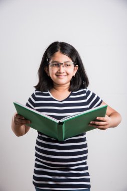 ayakta ve bir kitap, bir kitap ve beyaz arka plan üzerinde gözlük takıyor ve dururken kitap okuma sevimli Hintli kız okuma Asyalı küçük kız Okuma gözlükleri ile Hint küçük kız
