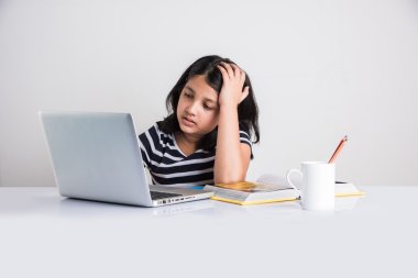 Dizüstü bilgisayarda çalışan yorgun Hintli kız.