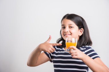 hintli küçük kız bir bardak mango suyu veya meyve suyu içme, asya kız ve meyve suyu bir bardak, hint küçük kız beyaz arka plan üzerinde mango suyu veya portakal suyu bir bardak tutan