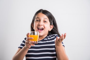 hintli küçük kız bir bardak mango suyu veya meyve suyu içme, asya kız ve meyve suyu bir bardak, hint küçük kız beyaz arka plan üzerinde mango suyu veya portakal suyu bir bardak tutan