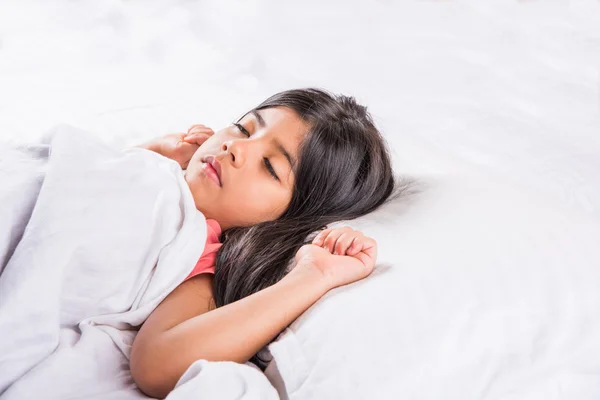 cute Indian Girl sleeping over white pillow, small asian girl sleeping on bed