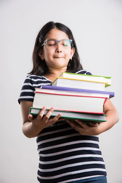 Petite fille indienne tenant un tas de livres, petite fille asiatique tenant un tas de livres dans les deux mains, se sentant lourd, expressions drôles — Photo