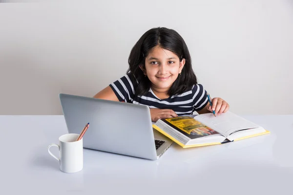Cute little indian girl studying on laptop, asian small girl studying and using laptop, innocent indian girl child and study concept with pile of books & laptop — Stock Photo, Image