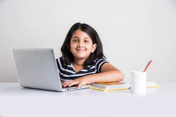 Cute little indian girl studying on laptop, asian small girl studying and using laptop, innocent indian girl child and study concept with pile of books & laptop — Stock Photo, Image