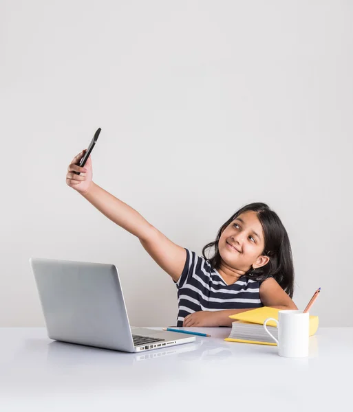 Cute little indian girl taking selfie while studying on laptop — Stock Photo, Image