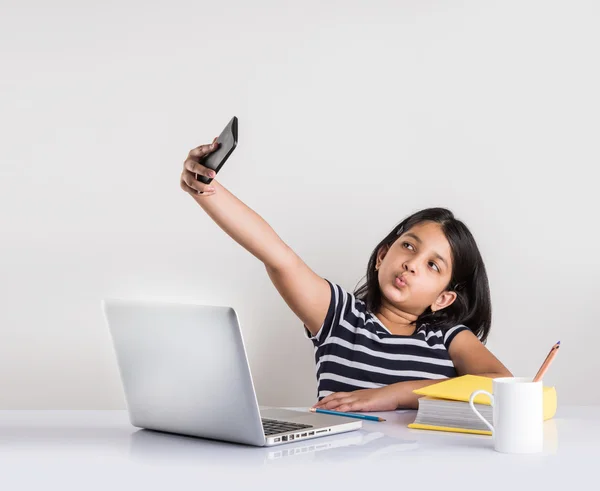 Cute little indian girl taking selfie while studying on laptop — Stock Photo, Image