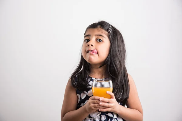 Indiase klein meisje mango sap of koud drankje of vruchtensap drinken in een glas — Stockfoto