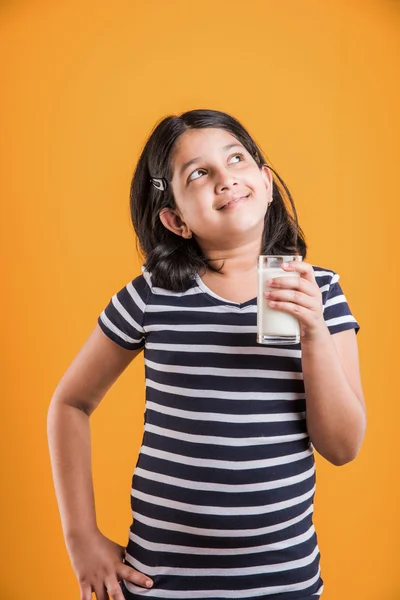 Indiase meisje met een glas melk, Aziatisch meisje drinken melk in een glas, portret van klein meisje drinken van melk in een glas — Stockfoto