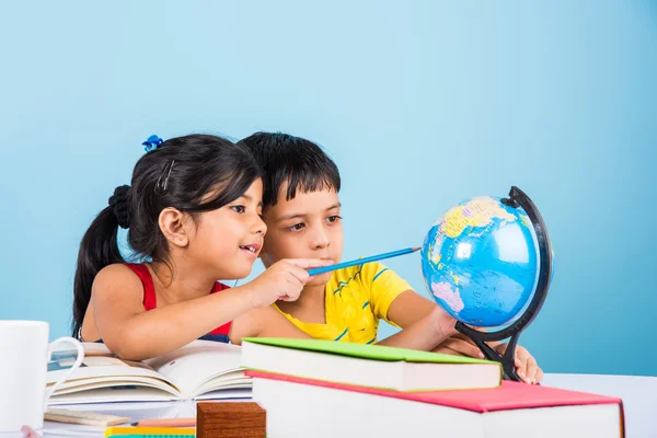 Indiase jongen en meisje studeren met globe op studielijst, Aziatische kinderen studeren, Indiase kinderen studeren geografie, kinderen doen van huiswerk of thuiswerk, twee kinderen studeren op tafel — Stockfoto