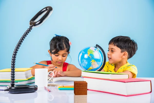 Niño y niña indios que estudian con el globo en la mesa de estudio, niños asiáticos que estudian, niños indios que estudian geografía, niños que hacen tareas o trabajo en casa, dos niños que estudian en la mesa — Foto de Stock