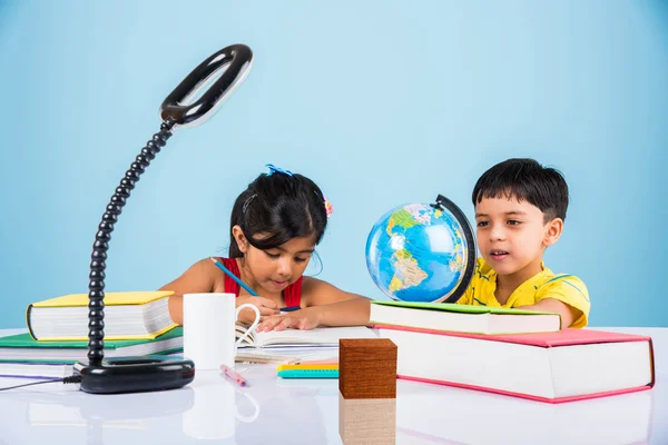 Niño y niña indios que estudian con el globo en la mesa de estudio, niños asiáticos que estudian, niños indios que estudian geografía, niños que hacen tareas o trabajo en casa, dos niños que estudian en la mesa — Foto de Stock