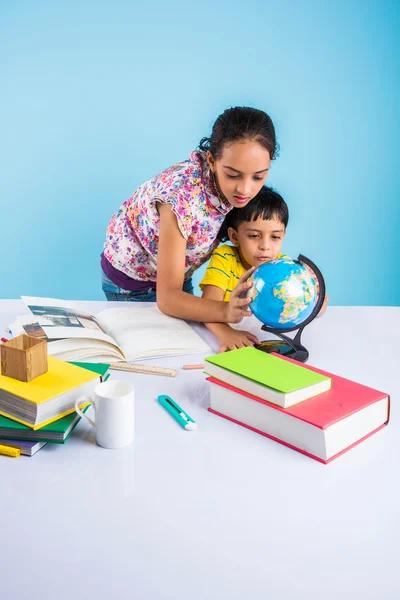 cute indian kids studying, smart asian girl and boy doing home work, indian siblings studying, indian small girl helping her brother in doing homework