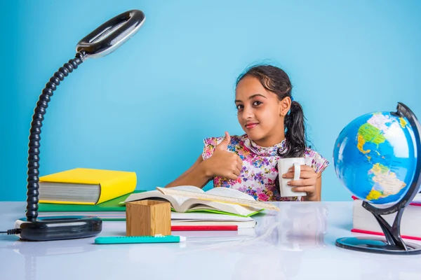 Educación y concepto de hogar - estudiante estresada chica con libros, niña india niño cansado de estudiar o hacer tareas, chica asiática estudiando y estresado, con globo juguete y taza de café — Foto de Stock