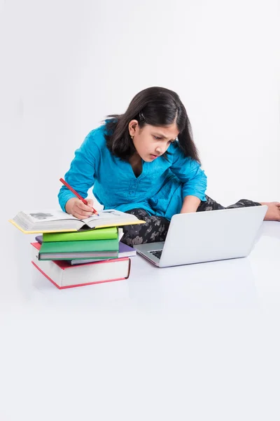 Mignonne petite fille indienne étudiant sur ordinateur portable, asiatique petite fille étudiant et utilisant ordinateur portable, innocent fille indienne enfant et étude concept avec pile de livres et ordinateur portable — Photo