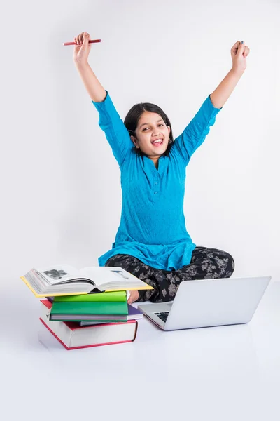 Linda niña india estudiando en el ordenador portátil, asiática niña pequeña estudiando y usando el ordenador portátil, inocente niña india niño y estudio concepto con pila de libros & portátil — Foto de Stock