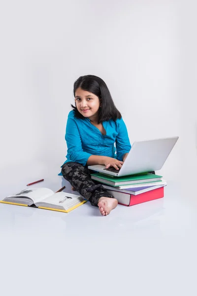 Cute little indian girl studying on laptop, asian small girl studying and using laptop, innocent indian girl child and study concept with pile of books & laptop — Stock Photo, Image