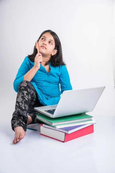 Linda niña india estudiando en el ordenador portátil, asiática niña pequeña estudiando y usando el ordenador portátil, inocente niña india niño y estudio concepto con pila de libros & portátil — Foto de Stock