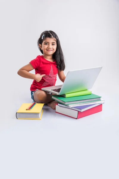 Mignonne petite fille indienne étudiant sur ordinateur portable, asiatique petite fille étudiant et utilisant ordinateur portable, innocent fille indienne enfant et étude concept avec pile de livres et ordinateur portable — Photo