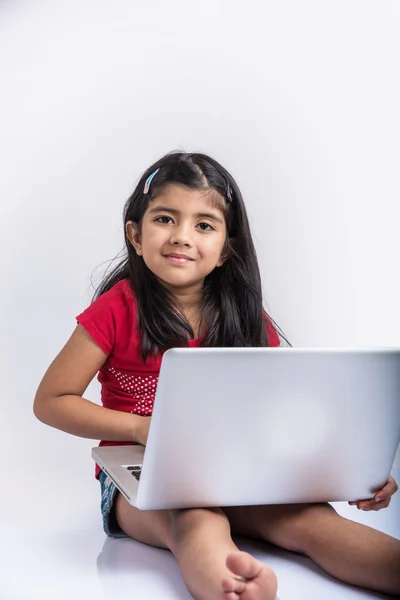 쾌활한 인도 어린 소녀 를 사용하여 노트북, 아시아 의 작은 소녀 재생 노트북, 고립 된 흰색 배경, 귀여운 인도 여자 거짓말 에 누워 바닥에 재생 에 노트북 — 스톡 사진
