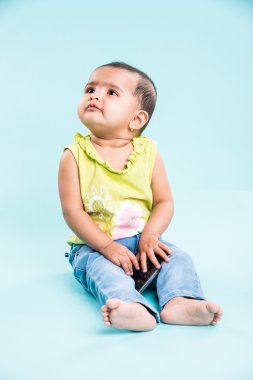 Cep telefonu mavi izole konuşmak kız mutlu bebek. Portre. Hint küçük kız ve hareket eden ya da cep telefonu, akıllı telefon kullanan Asya bebek kız