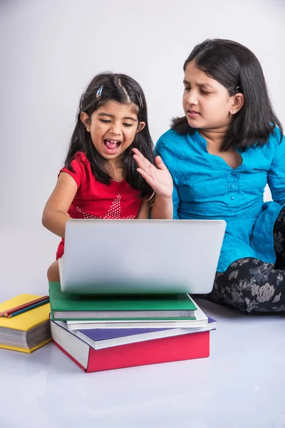 Two indian small girls studying on laptop with pile of books, asian small girls and homework using laptop, group study concept — Stock Photo, Image