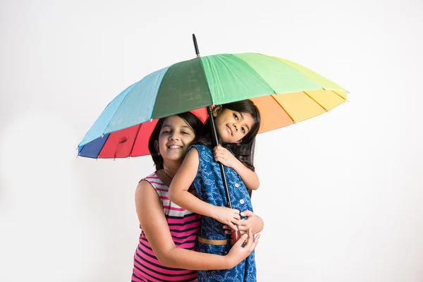 Två små indiska flickor med färgglada paraply, isolerade över vitt — Stockfoto