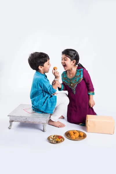 Hermano pequeño indio y hermana disfrutando y celebrando el festival Raksha Bandhan — Foto de Stock