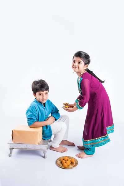 Индийский младший брат и сестра наслаждаются и празднуют фестиваль Ракша Бандхан — стоковое фото