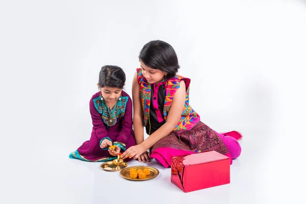 Duas meninas pequenas indianas bonitos no desgaste tradicional preparando pooja thali ou puja thali — Fotografia de Stock