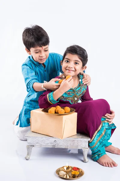 Indisk lillebror og søster nyder og fejrer Raksha Bandhan festival - Stock-foto