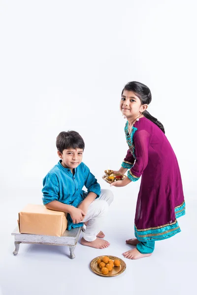 Hermano pequeño indio y hermana disfrutando y celebrando el festival Raksha Bandhan — Foto de Stock