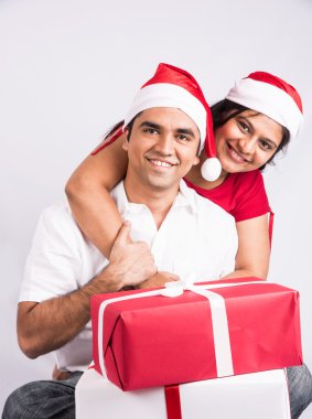 Genç Hintli çift Noel hediyesiyle gülümsüyor, Asyalı çift ve noel hediyesi, Noel Baba şapkası, beyaz arka plan, Hindistan ve Noel kutlaması, Noel hediyesi ve Hintli çift