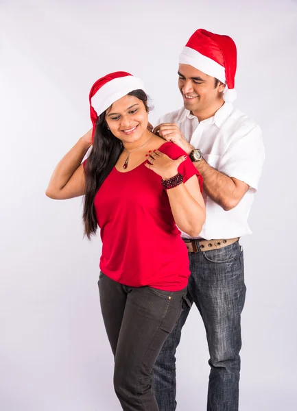 Man placing necklace on woman\'s neck in christmas time, indian man gifting necklace to wife of girlfriend on christmas, asian couple and gifting necklace, isolated on white background, standing pose