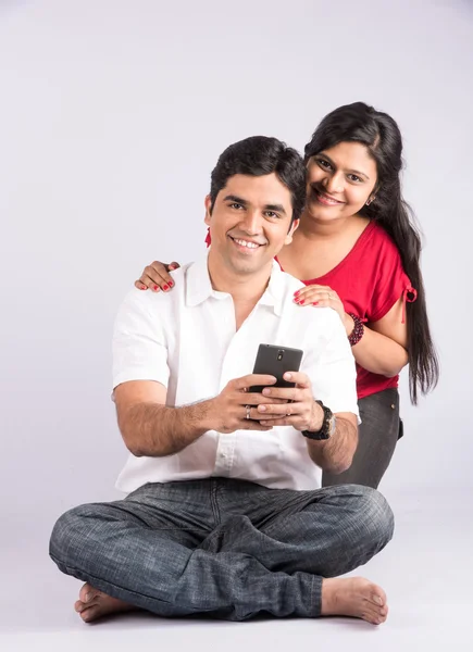 크리스마스 시간에 스마트 폰을 들고 행복한 인도 커플, 아시아 커플과 스마트 폰, 흰색 배경, 전면보기에 고립 — 스톡 사진