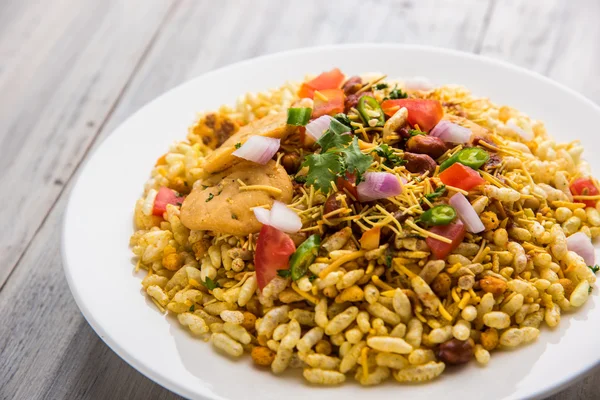 Makanan ringan India Bhel Puri disajikan dengan tomat cincang, cabai hijau, daun ketumbar — Stok Foto