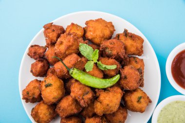 Lezzetli lezzetli ve nefis Hint Moong Dal vada veya moong dal pakoda veya moong vade veya Pakora (börek) ile kızarmış yeşil biber, kırmızı ve yeşil acı sos.