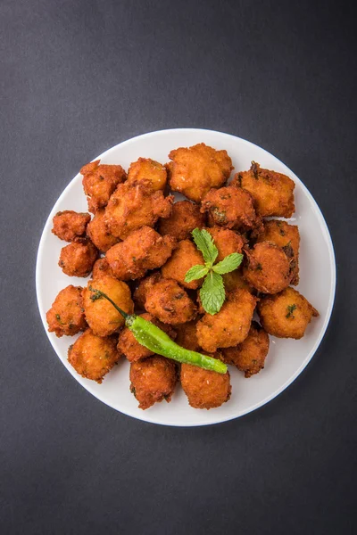 Läckra läckra och smaskiga indiska Moong Dal vada eller moong dal pakoda eller moong vade eller Pakora (plottra) med stekt grön chili, röda och gröna hot sås. — Stockfoto