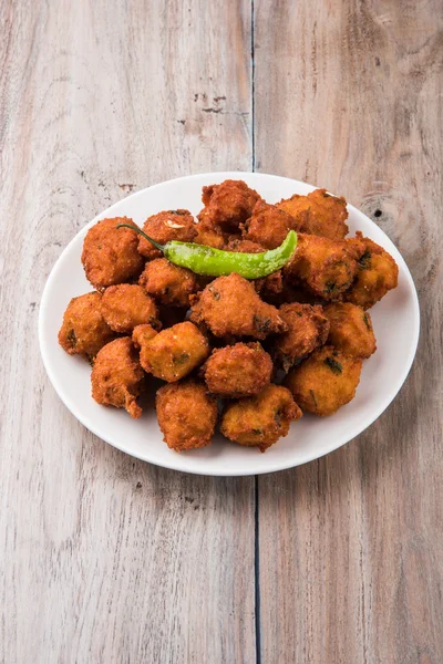 Läckra läckra och smaskiga indiska Moong Dal vada eller moong dal pakoda eller moong vade eller Pakora (plottra) med stekt grön chili, röda och gröna hot sås. — Stockfoto