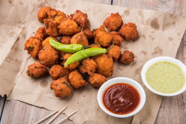 Lezzetli lezzetli ve nefis Hint Moong Dal vada veya moong dal pakoda veya moong vade veya Pakora (börek) ile kızarmış yeşil biber, kırmızı ve yeşil acı sos.