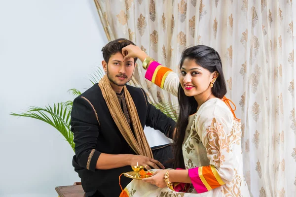 Indische Schwester trägt Tika auf die Stirn des Bruders auf, genießt und feiert Raksha Bandhan Festival — Stockfoto