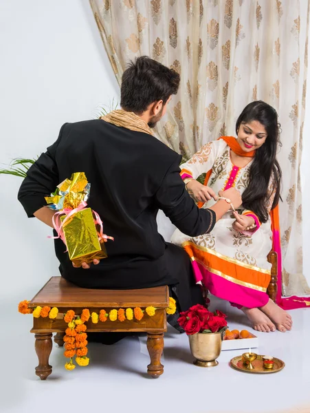 Indian sister applying tika on brother's forehead, enjoying and celebrating Raksha Bandhan festival — Stock Photo, Image