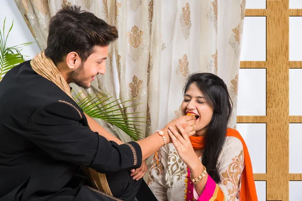 Indian sister applying tika on brother's forehead, enjoying and celebrating Raksha Bandhan festival — Stock Photo, Image