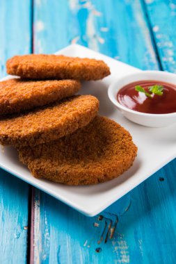 Hint sohbet madde aloo veya aalu tikki veya tikiya veya ragda köftesi ile domates ketçap, seçici odak hizmet olarak da bilinen kızarmış patates kek