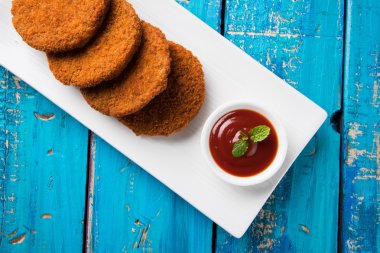 Hint sohbet madde aloo veya aalu tikki veya tikiya veya ragda köftesi ile domates ketçap, seçici odak hizmet olarak da bilinen kızarmış patates kek