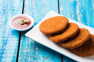 Hint sohbet madde aloo veya aalu tikki veya tikiya veya ragda köftesi ile domates ketçap, seçici odak hizmet olarak da bilinen kızarmış patates kek