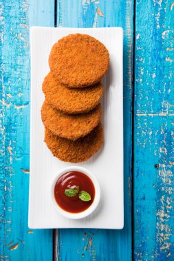 Hint sohbet madde aloo veya aalu tikki veya tikiya veya ragda köftesi ile domates ketçap, seçici odak hizmet olarak da bilinen kızarmış patates kek