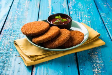 Hint sohbet madde aloo veya aalu tikki veya tikiya veya ragda köftesi ile domates ketçap, seçici odak hizmet olarak da bilinen kızarmış patates kek