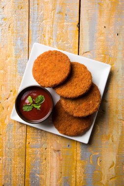 Hint sohbet madde aloo veya aalu tikki veya tikiya veya ragda köftesi ile domates ketçap, seçici odak hizmet olarak da bilinen kızarmış patates kek