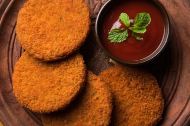 Hint sohbet madde aloo veya aalu tikki veya tikiya veya ragda köftesi ile domates ketçap, seçici odak hizmet olarak da bilinen kızarmış patates kek