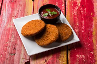 Hint sohbet madde aloo veya aalu tikki veya tikiya veya ragda köftesi ile domates ketçap, seçici odak hizmet olarak da bilinen kızarmış patates kek